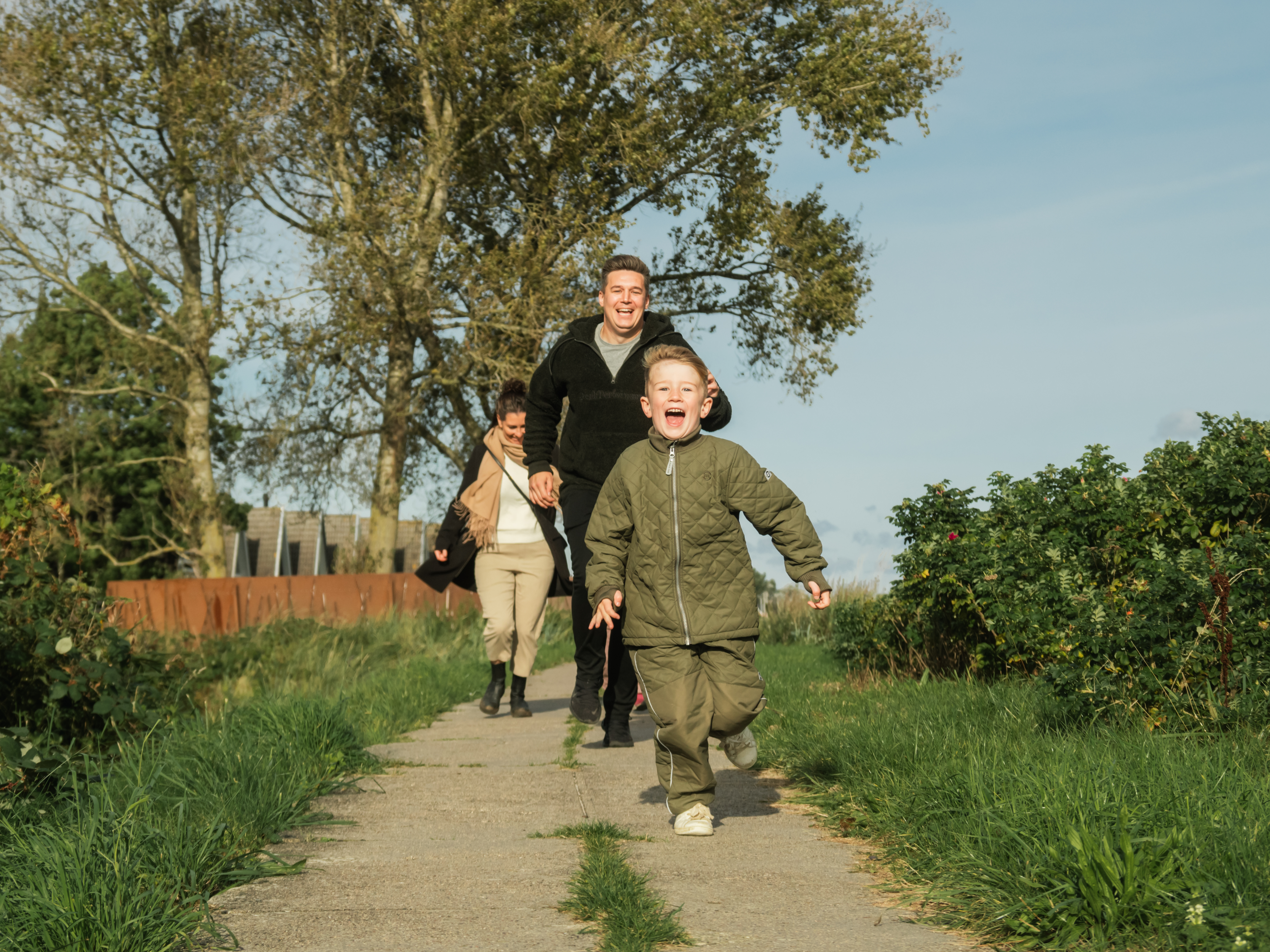 Familie, der løber langs diget ved Hasmark Strandoase